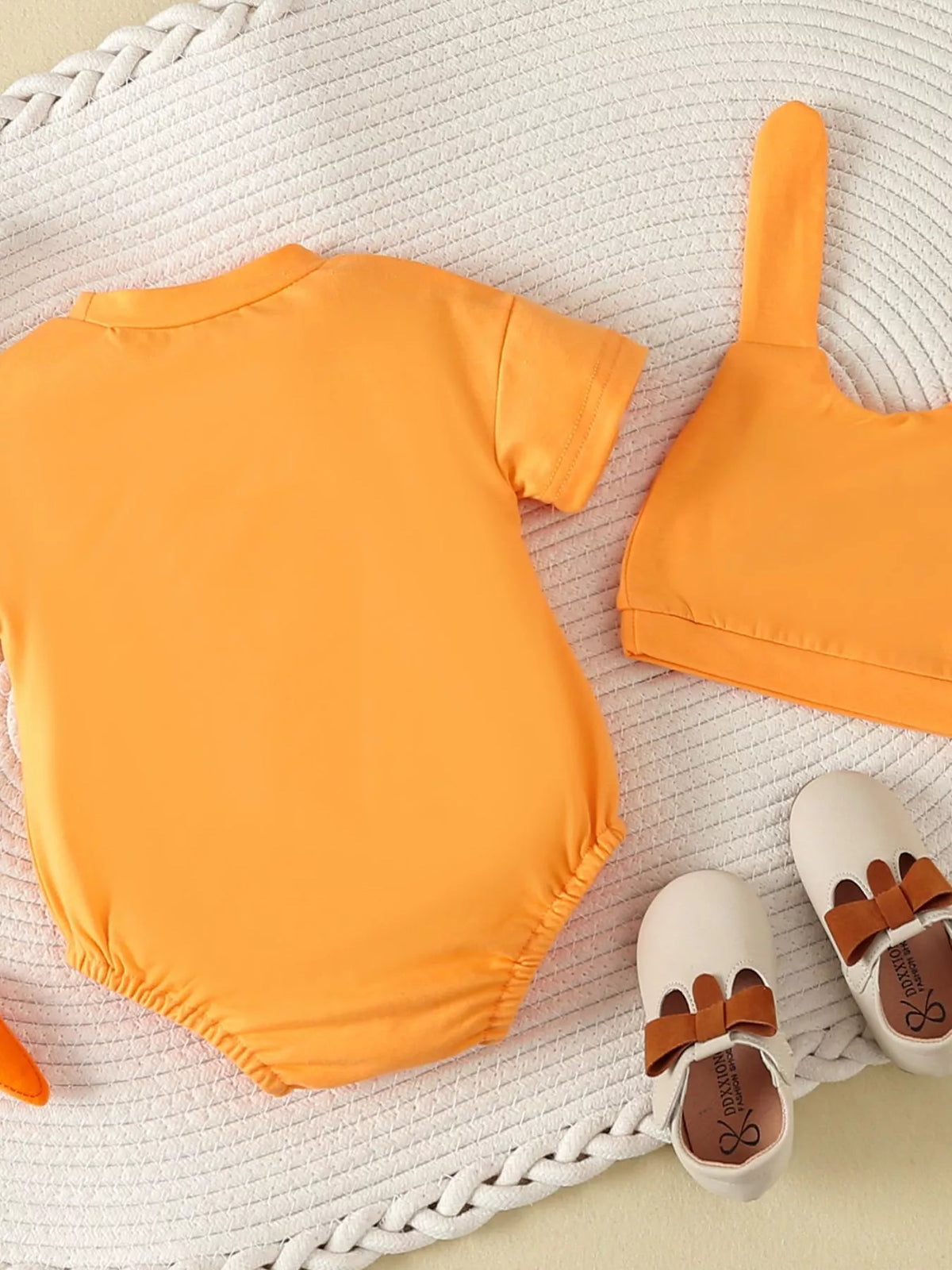 Back of the orange bodysuit beside bunny-ear hat