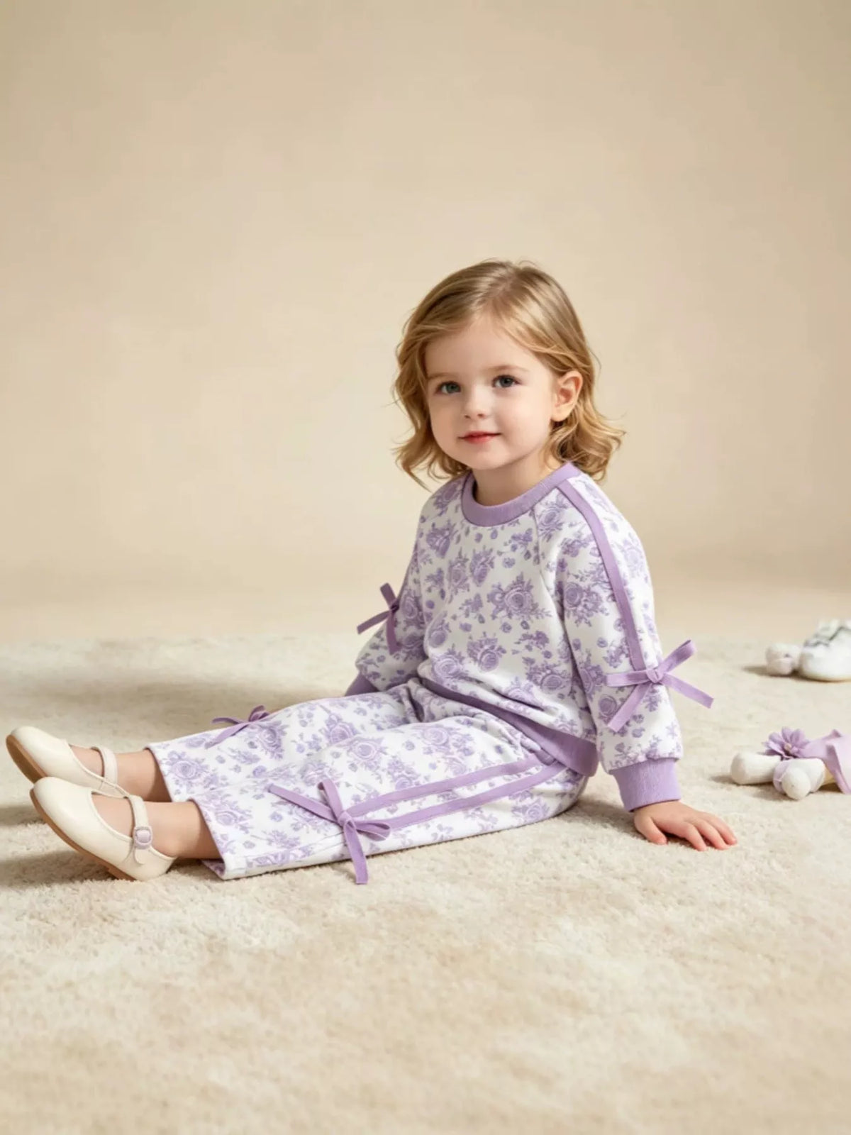 Side view of the lavender floral outfit on a seated child
