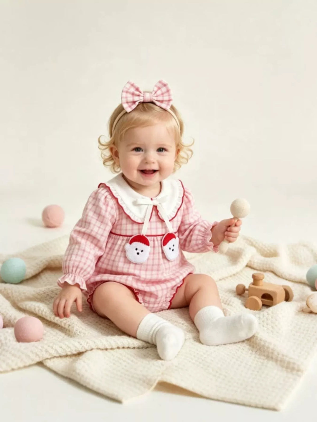 Baby in the gingham outfit with arms raised