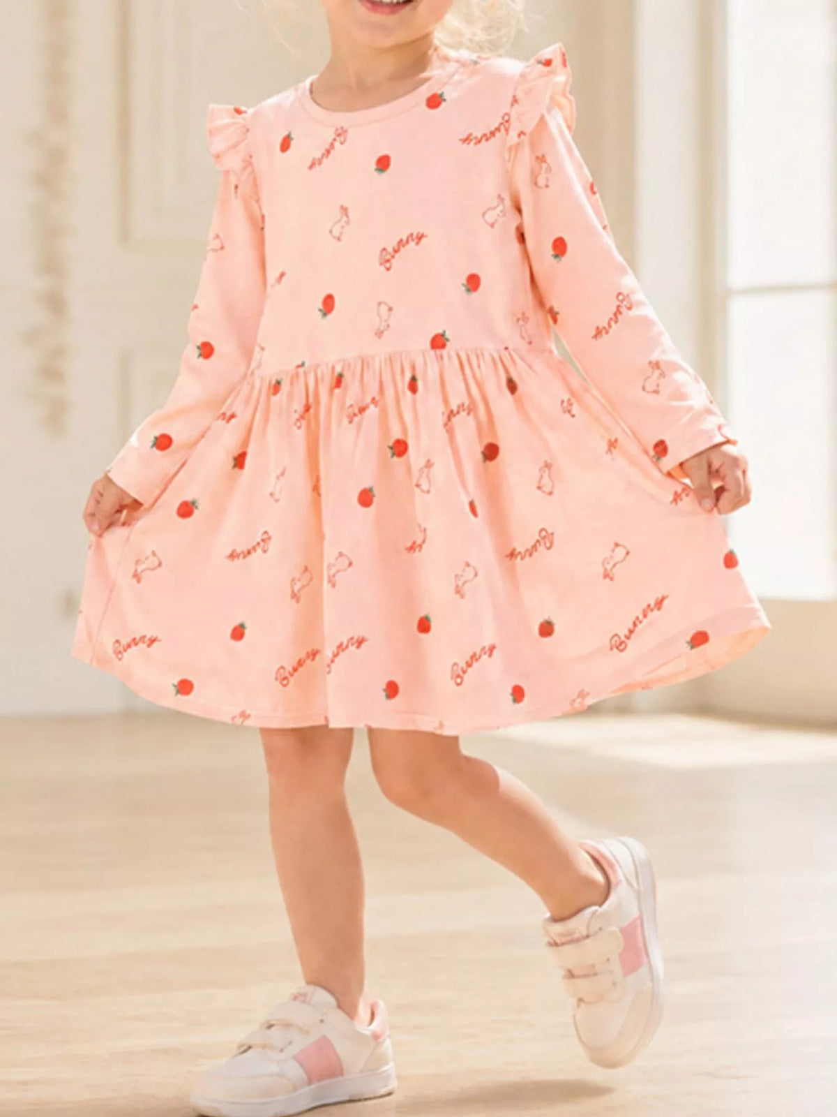 Peach strawberry-and-bunny ruffle-shoulder long-sleeve dress on a child