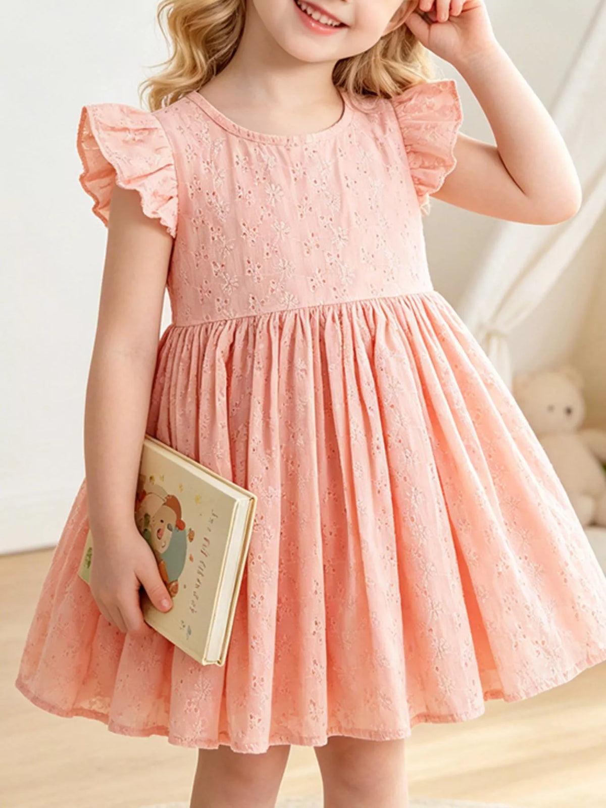 Peach eyelet flutter-sleeve dress with a gathered skirt on a child