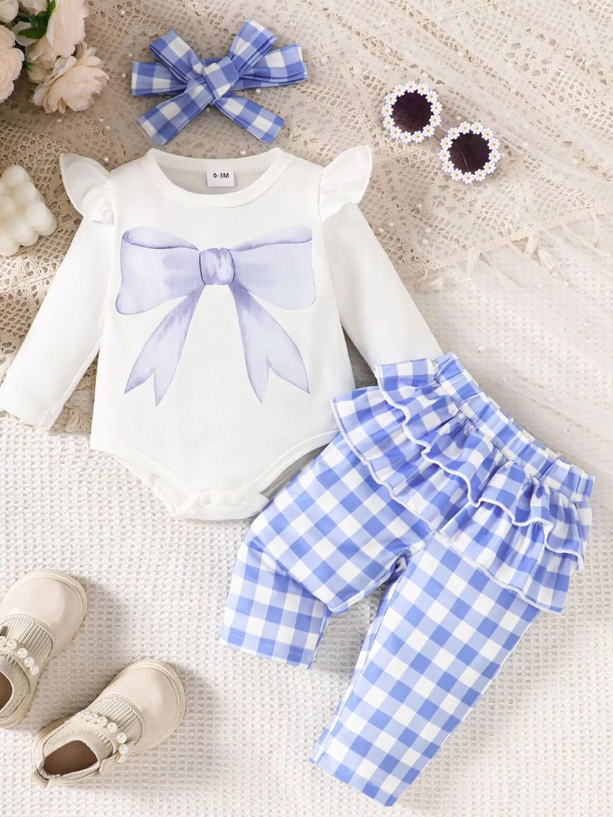 White bodysuit with blue gingham pants and headband laid flat
