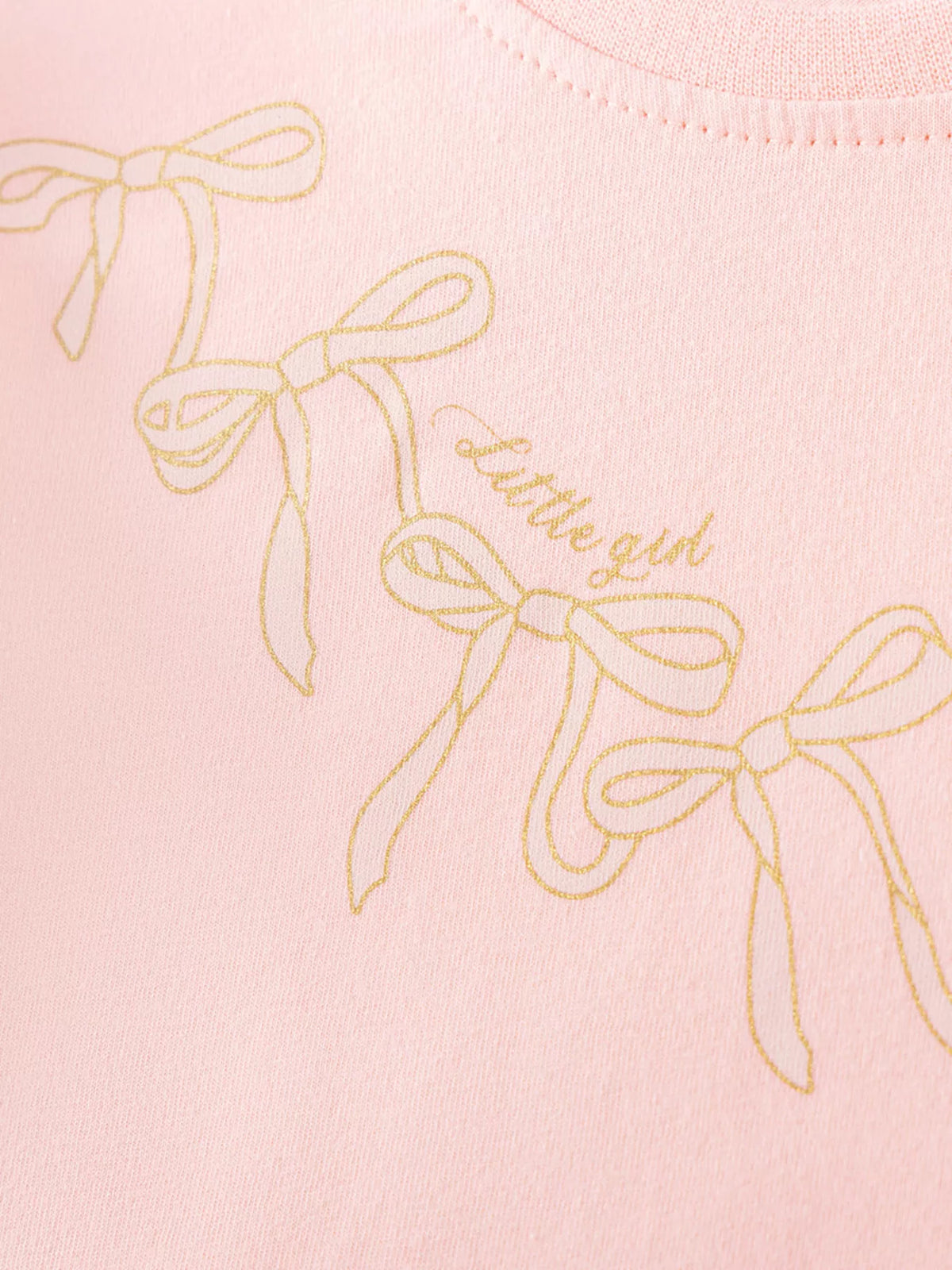 Gold outlined bow motifs on the peach bodice