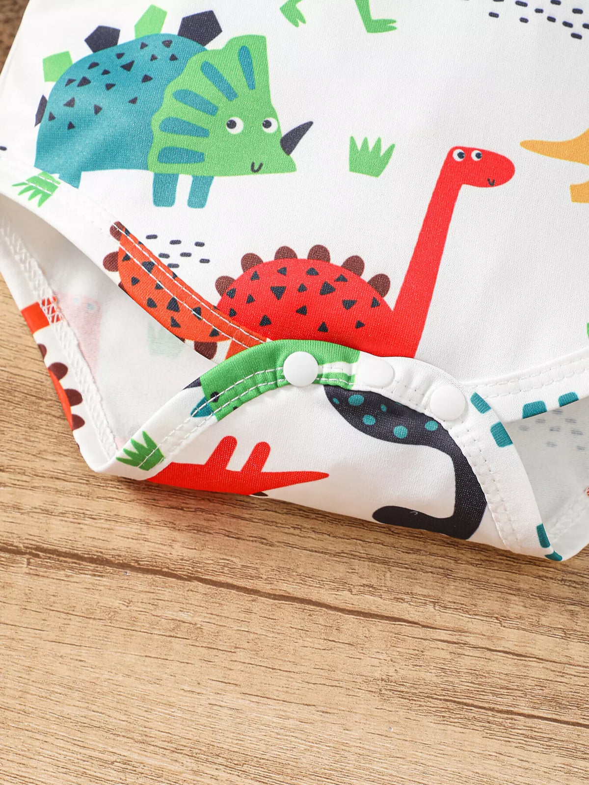 Dinosaur Wild Boy hooded bodysuit and orange pants — bodysuit bottom snaps