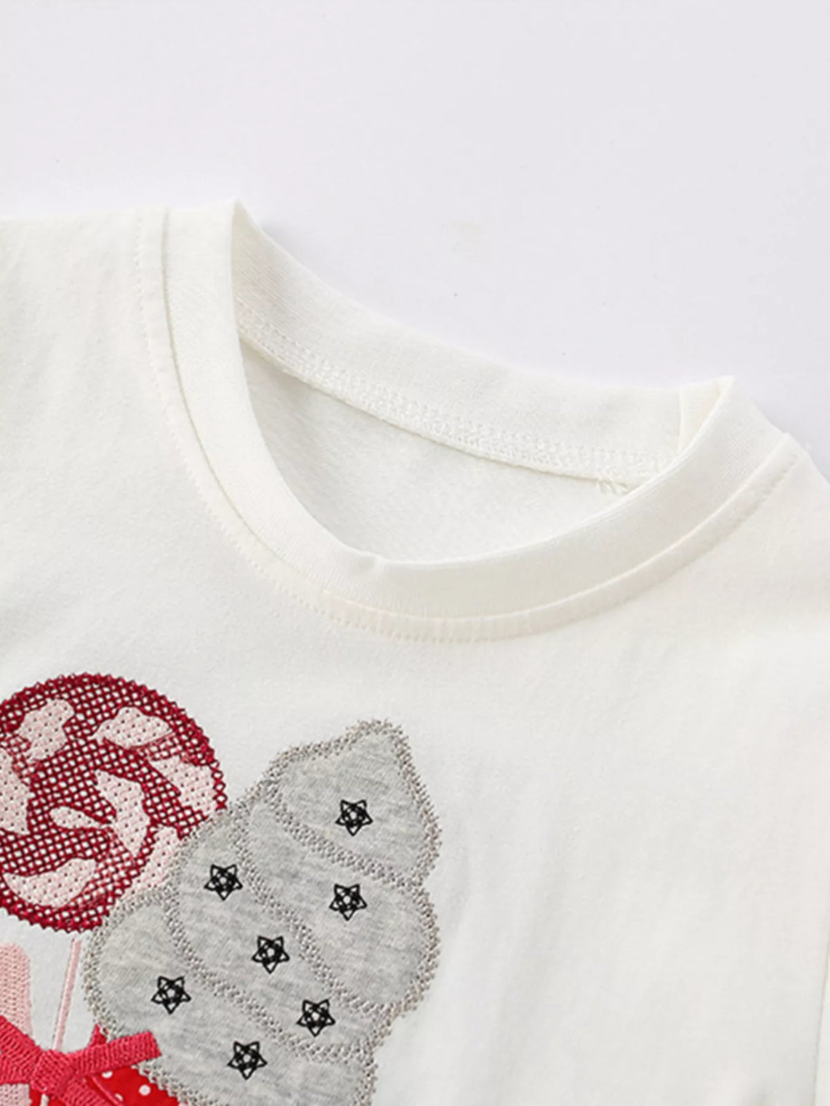 White sequin ice cream ruffle hem top — round neckline and graphic