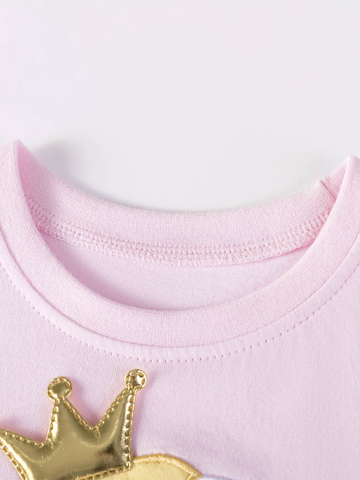 Pink ribbed neckline above gold crown detail