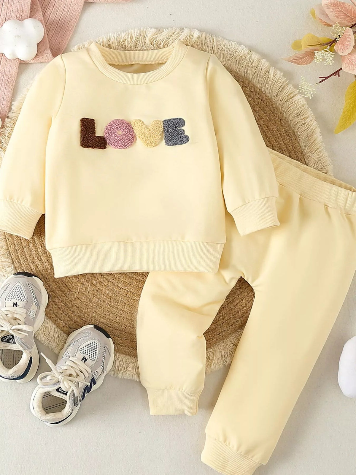 Pale yellow Love top and pants laid flat
