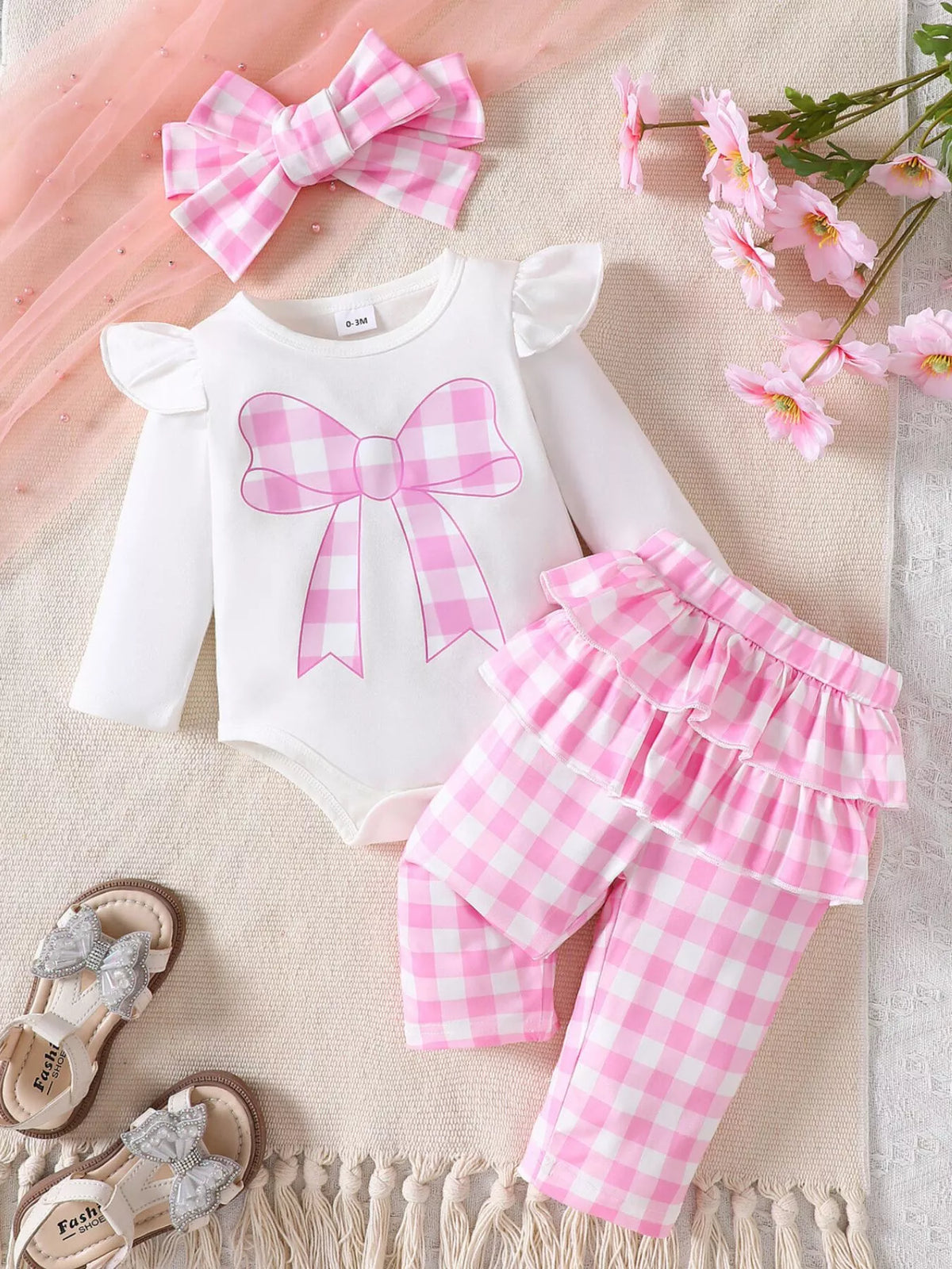 White bodysuit with pink gingham pants and headband laid flat