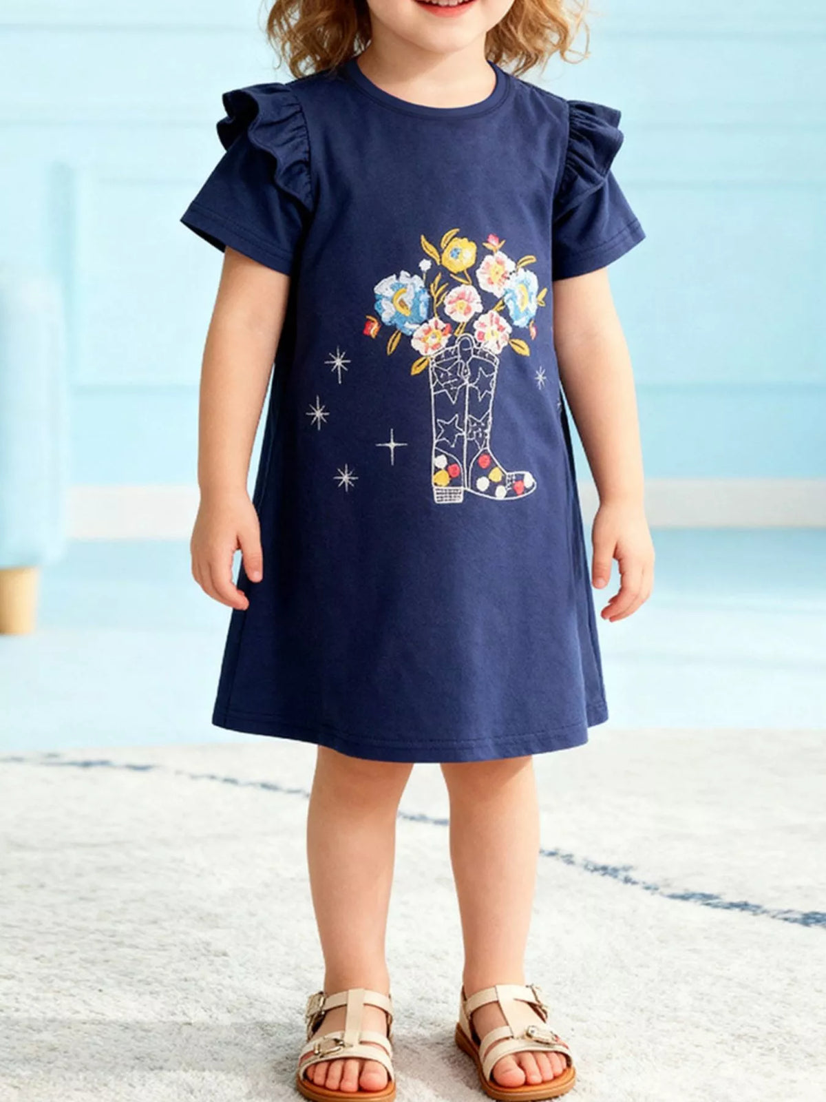 Navy ruffle-sleeve dress with a floral boot graphic on a child