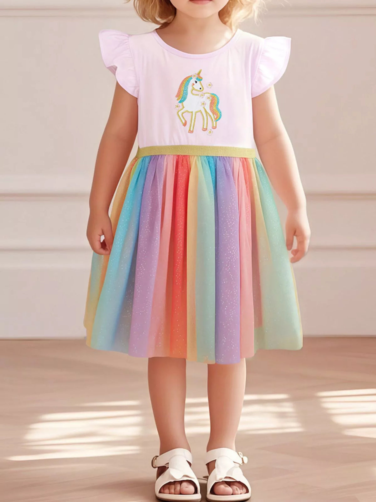 Pale pink unicorn dress with a rainbow tulle skirt on a child