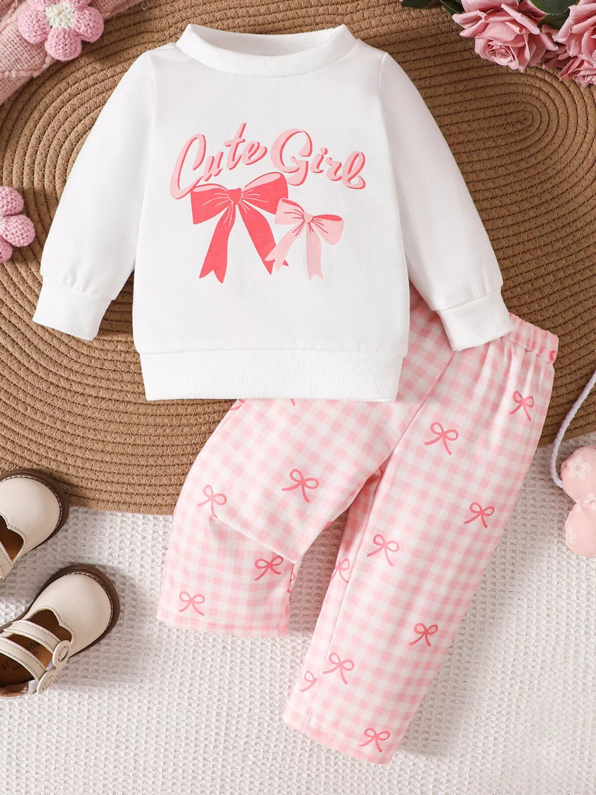 White bow-graphic sweatshirt with pink gingham pants laid flat