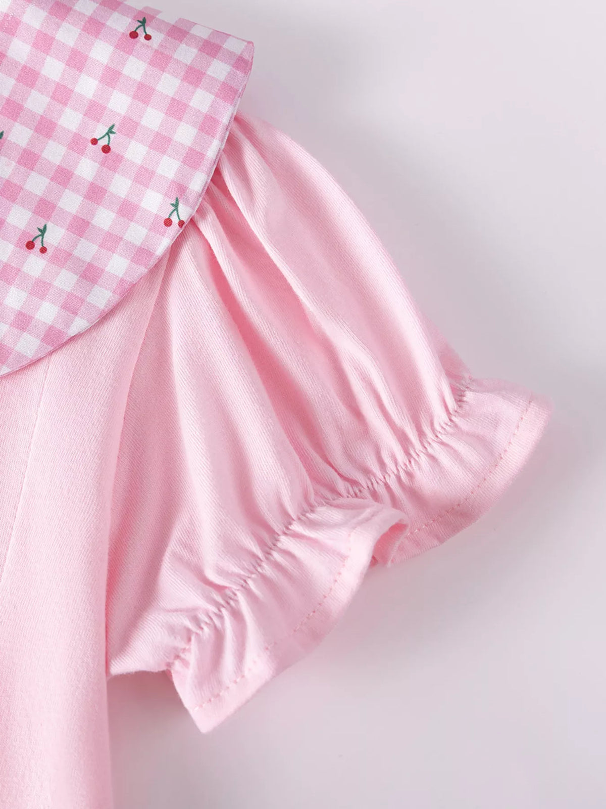 Gathered pink puff sleeve beside the gingham collar