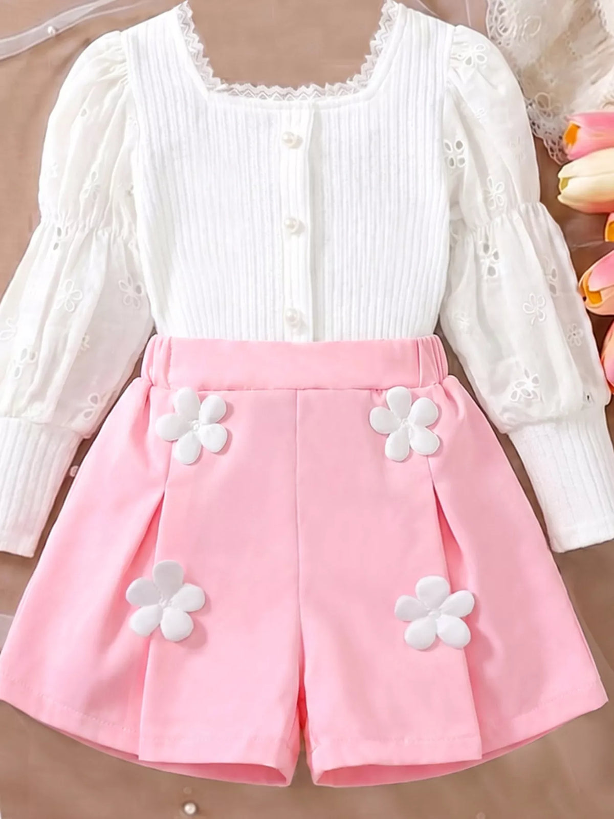 Front of the white top and pink flower-detail shorts