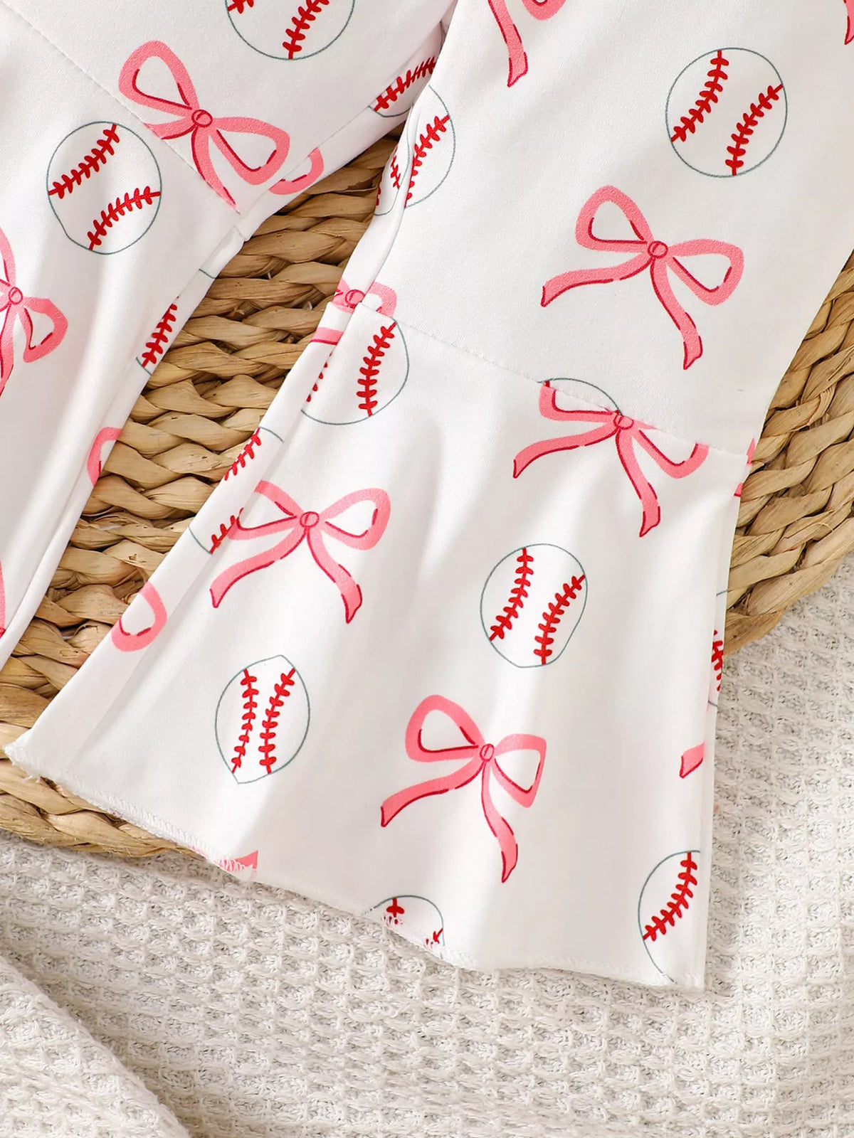 Baseball and pink bow motifs on flared pant legs