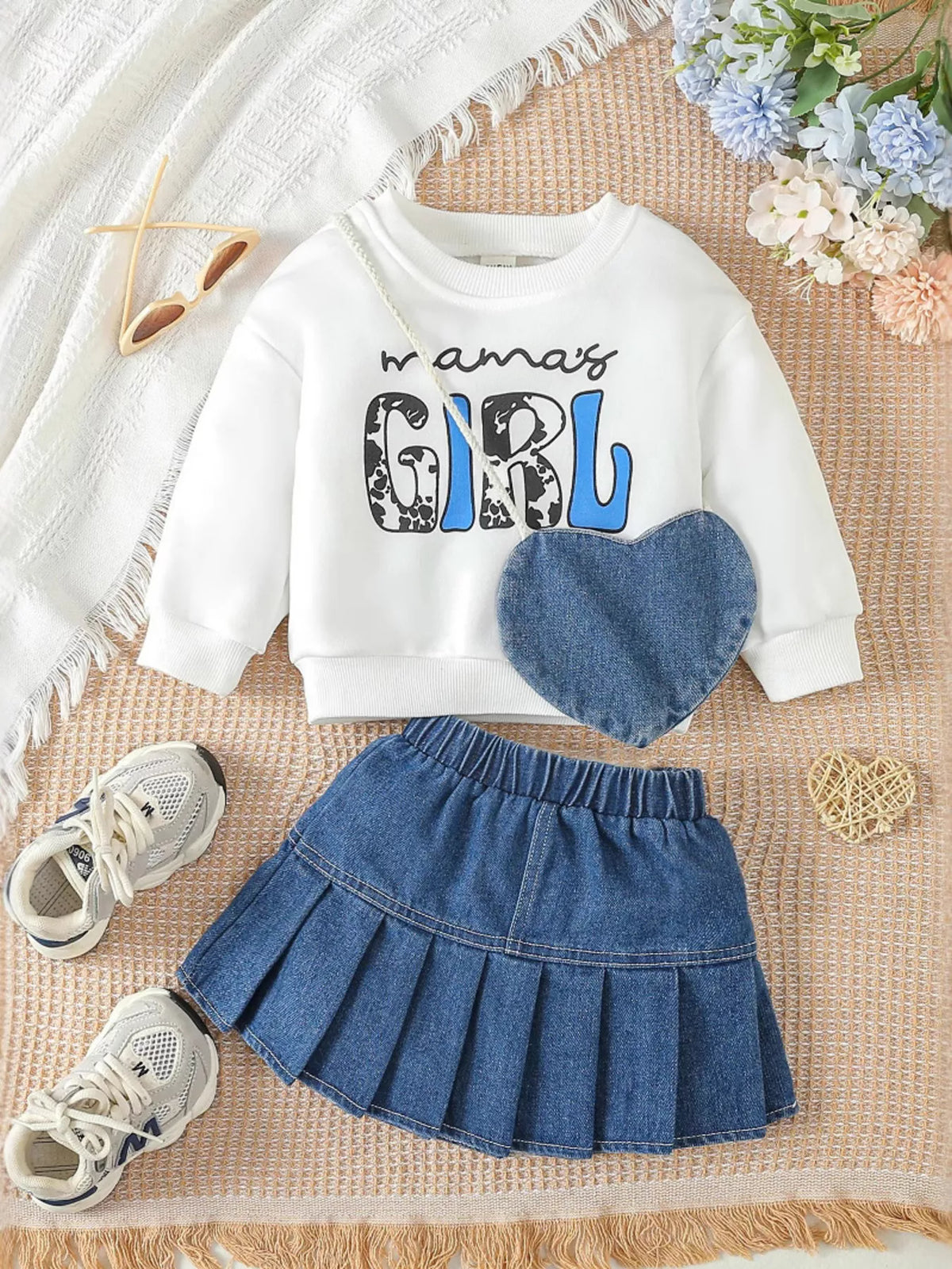 Outfit laid flat beside a denim heart bag
