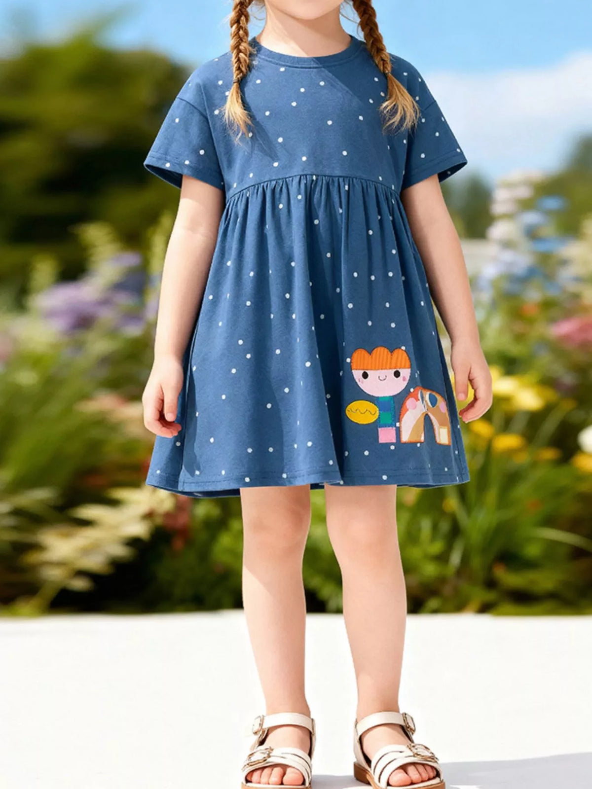 Blue polka-dot short-sleeve dress with colorful motifs on a child