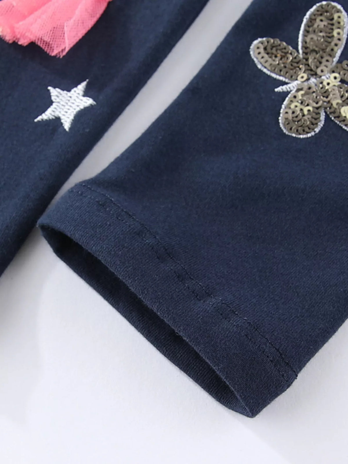 Butterfly motif above the straight ankle hem