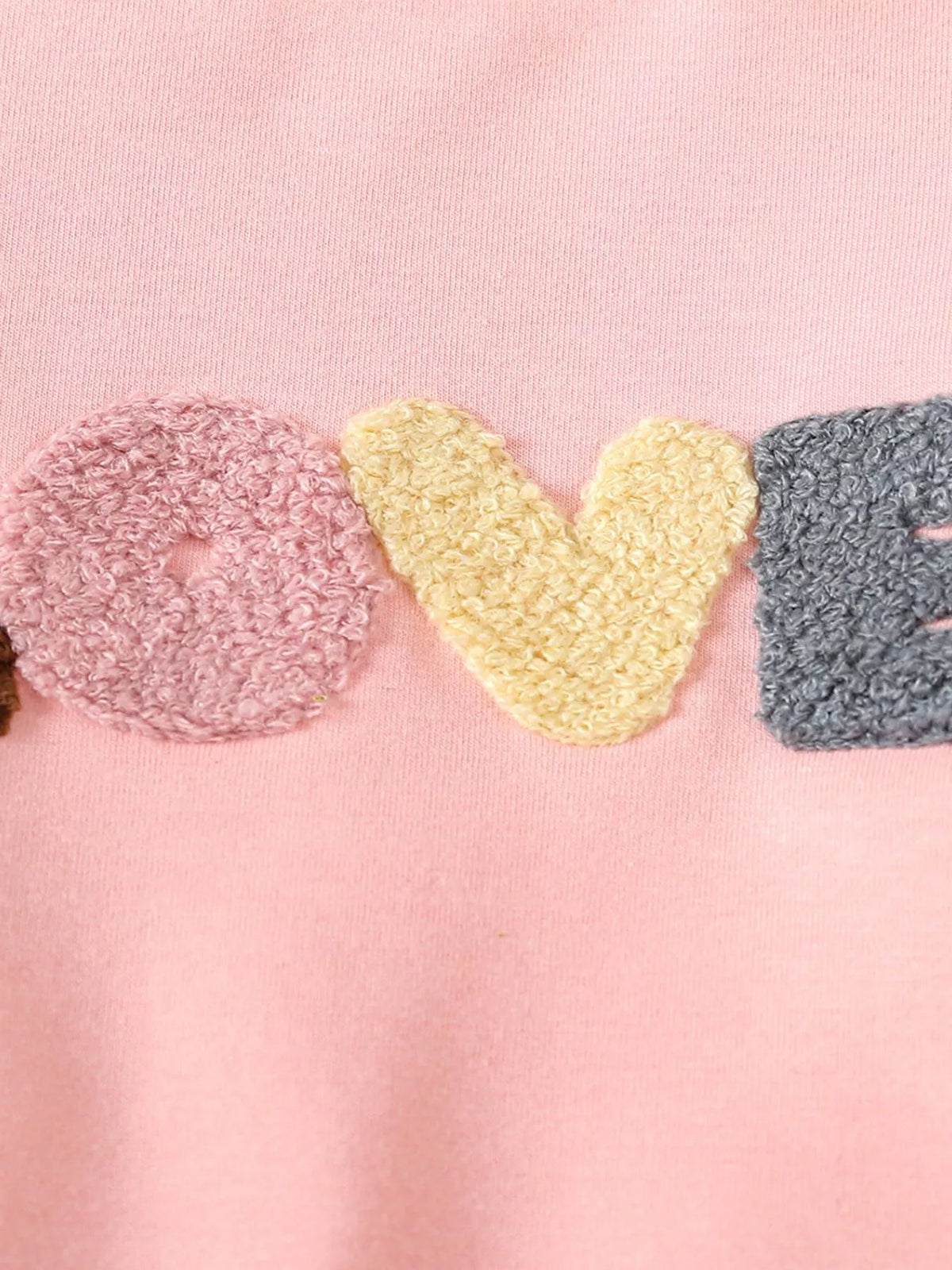 Multicolored textured Love applique on pink fabric