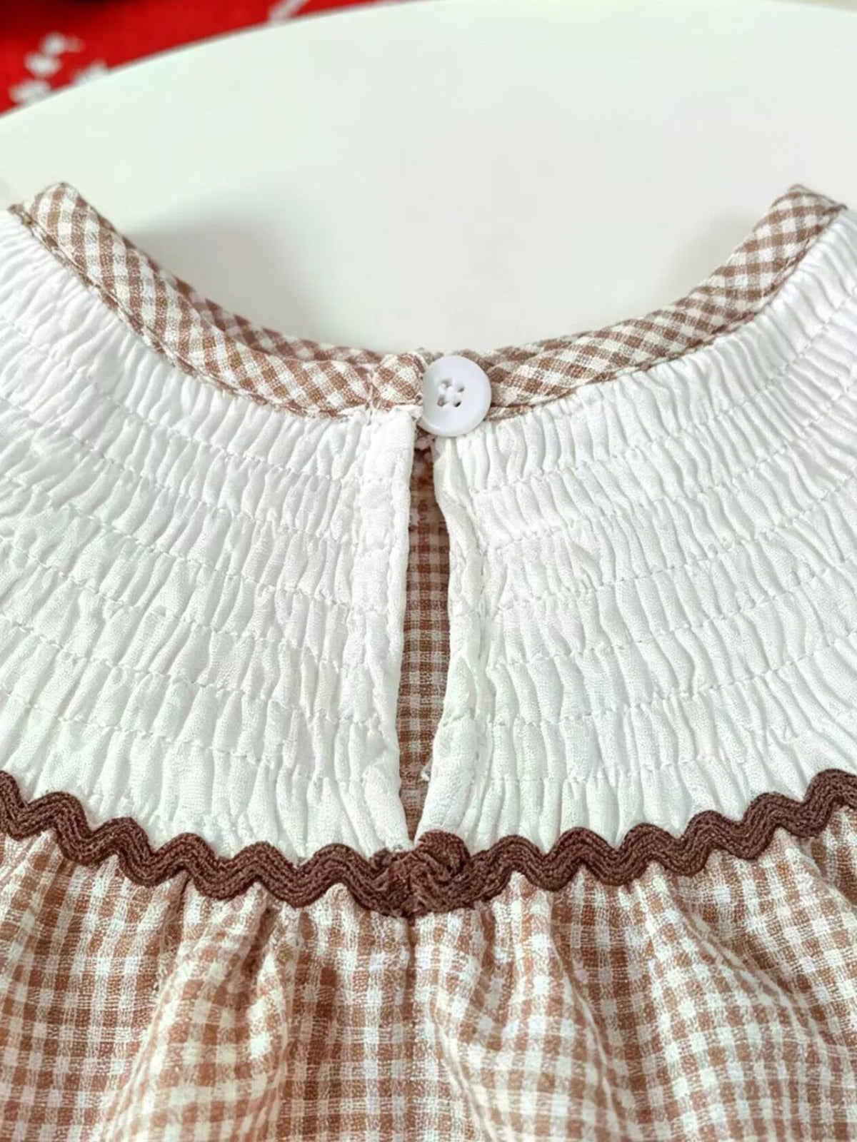 Back keyhole button closure at the smocked neckline