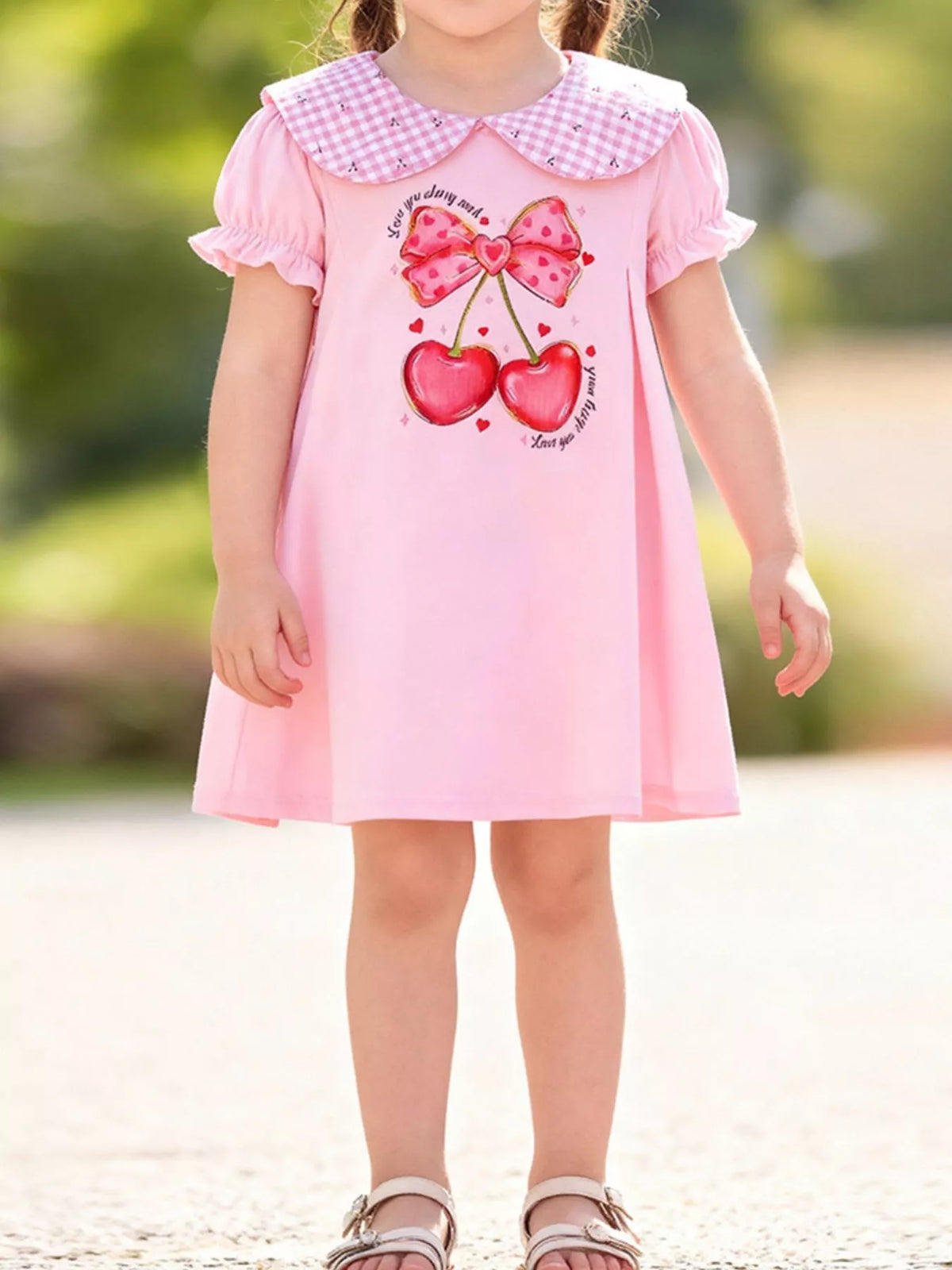 Pink cherry dress with a gingham Peter Pan collar on a child