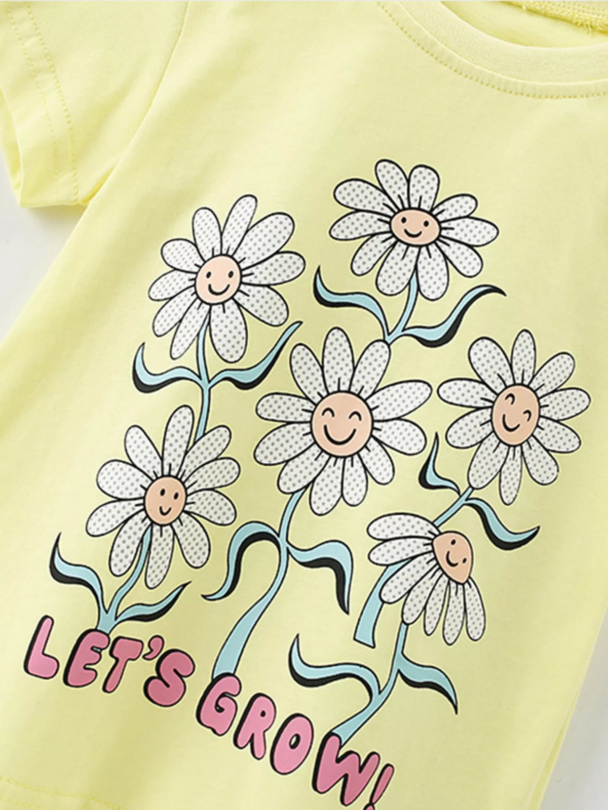Yellow daisy graphic shirt — smiling daisies and let's grow lettering