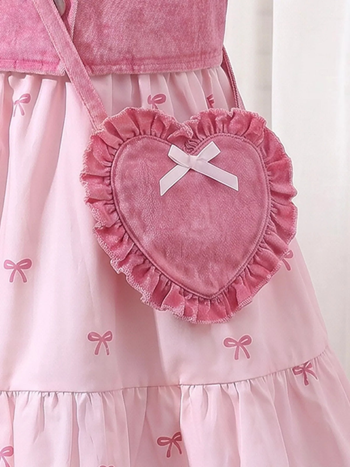 Ruffled pink heart-shaped bag with a white bow