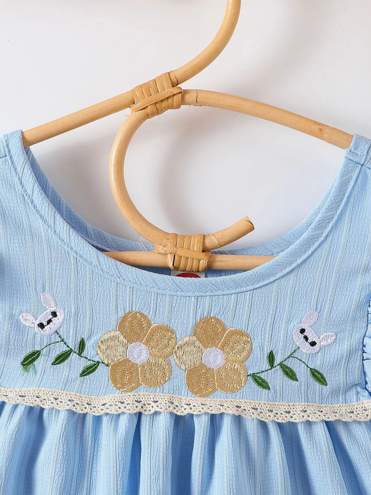 Flower embroidery across the blue bodice