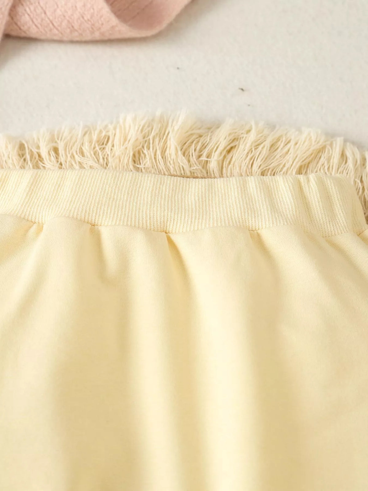 Elastic waistband on pale yellow pants