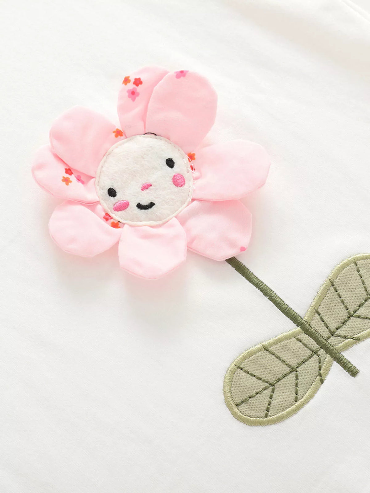 White flower applique ruffle sleeve top and green striped leggings — dimensional smiling pink flower