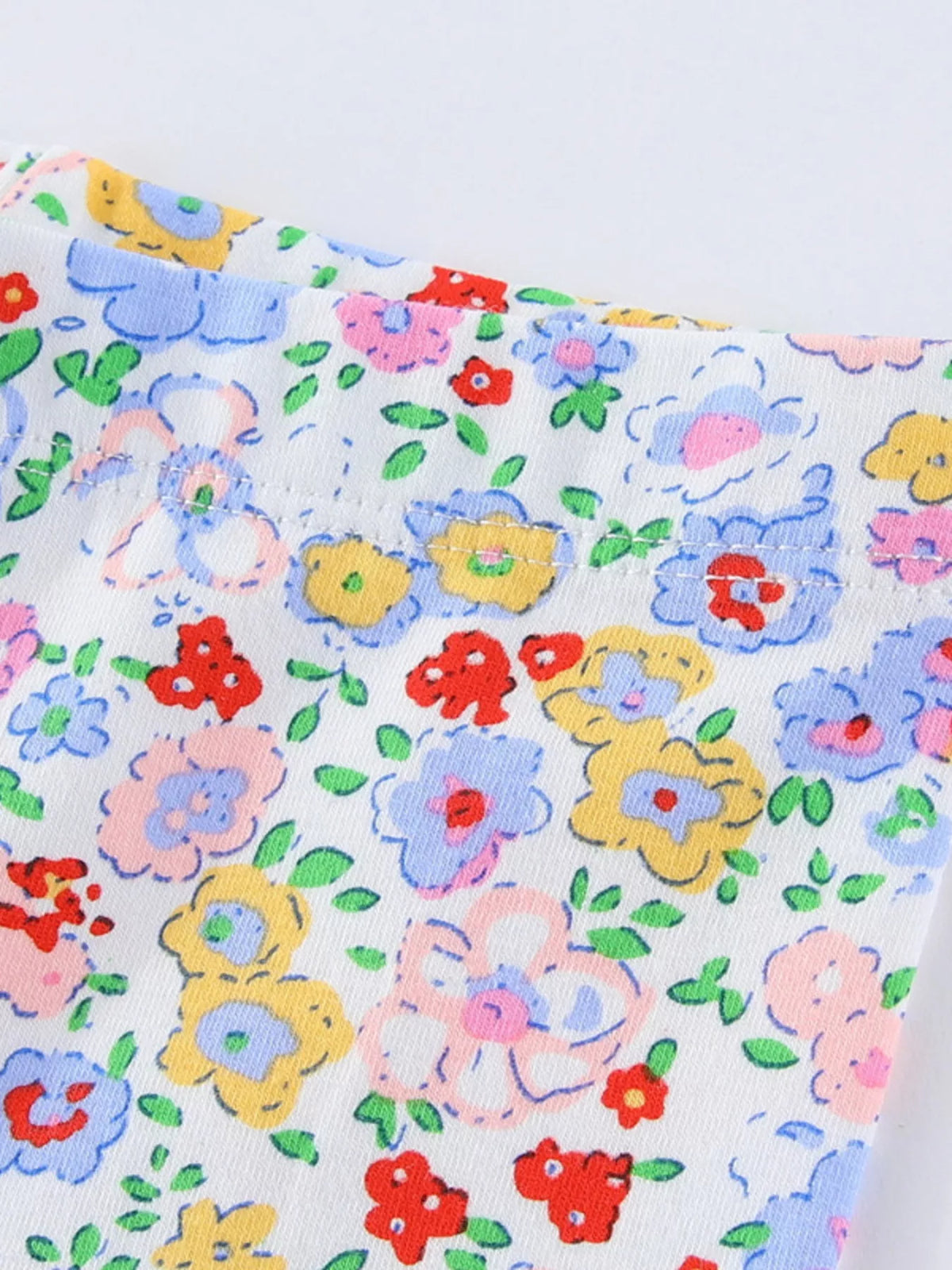 Small blue, pink and yellow flowers on white fabric