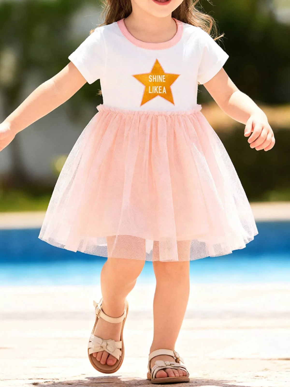 White star-graphic dress with a peach tulle skirt on a child