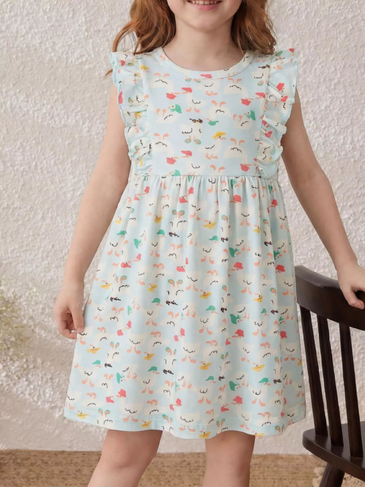 Ivory cartoon-print dress with ruffled sleeves on a child