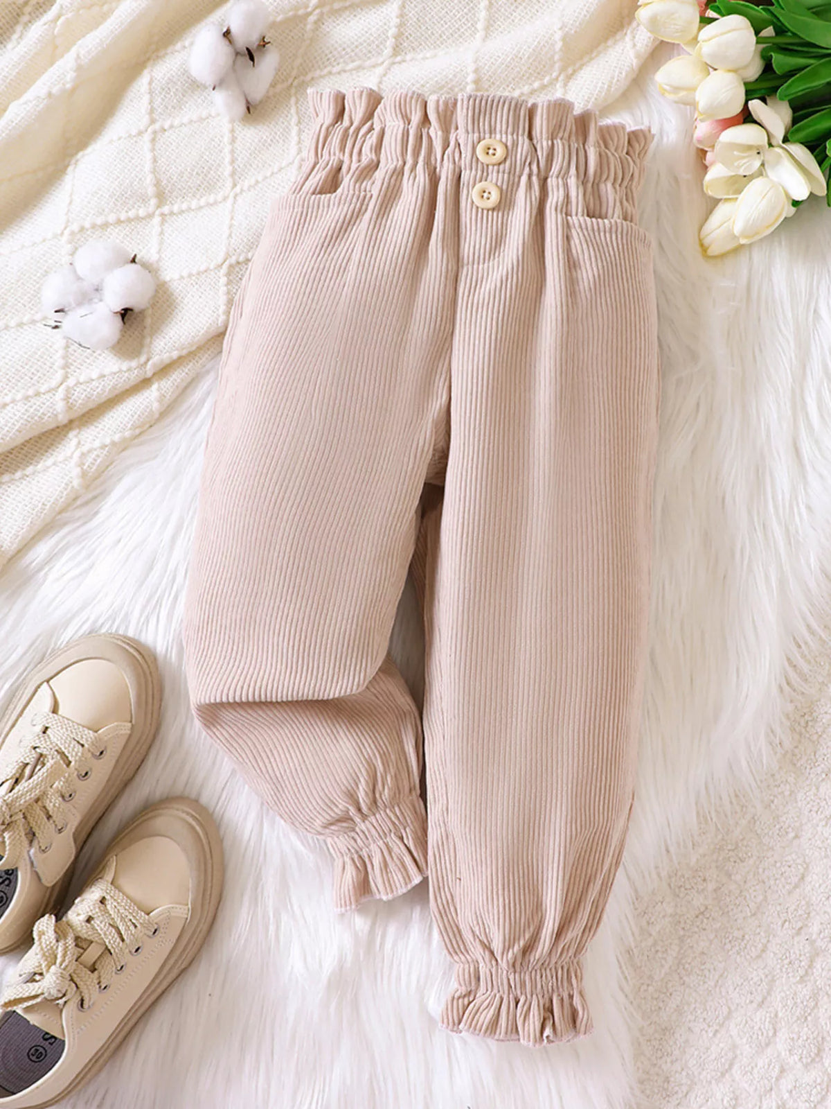 Beige corduroy pants laid flat
