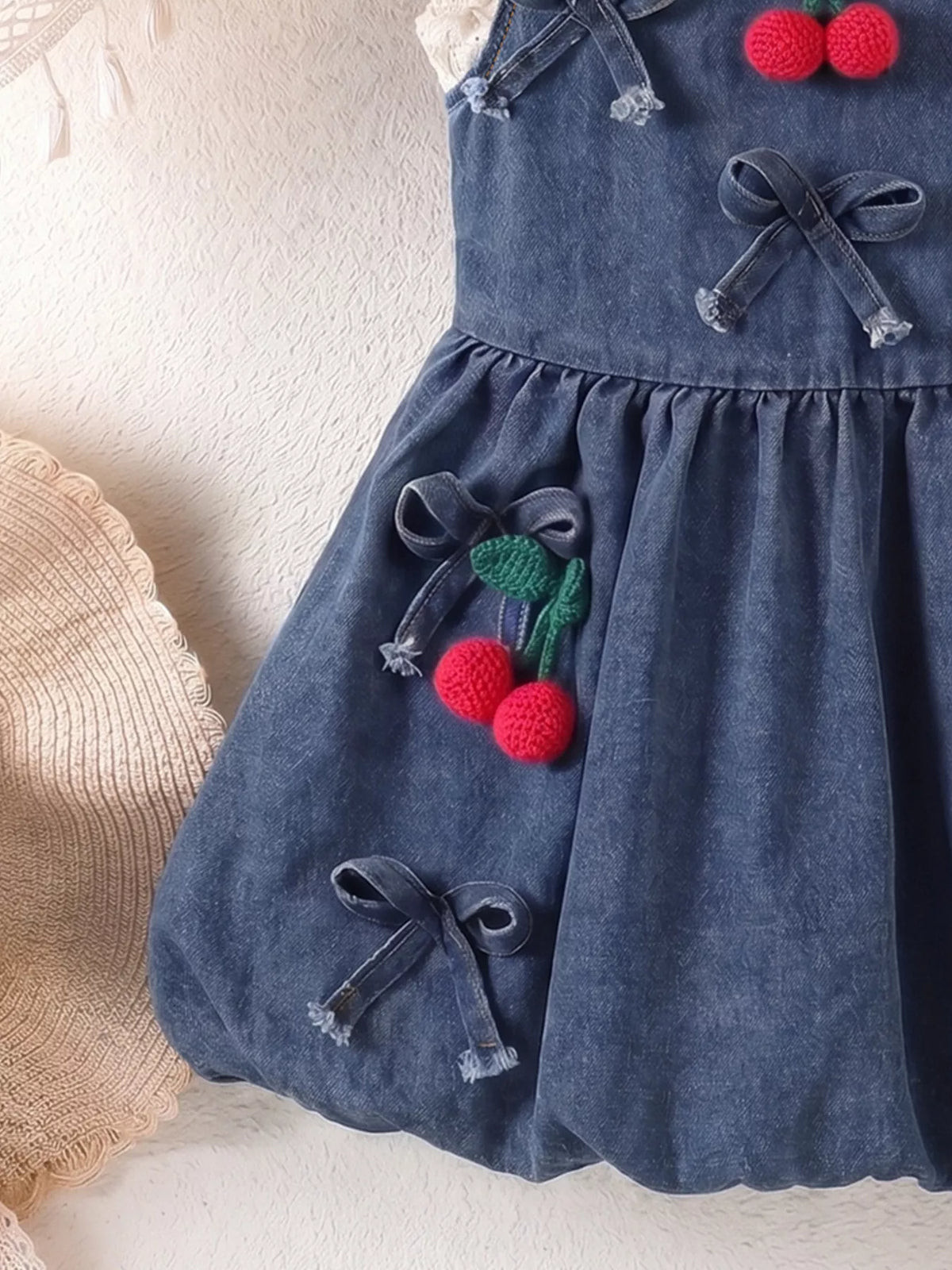 Denim bows and cherry appliques on the gathered skirt