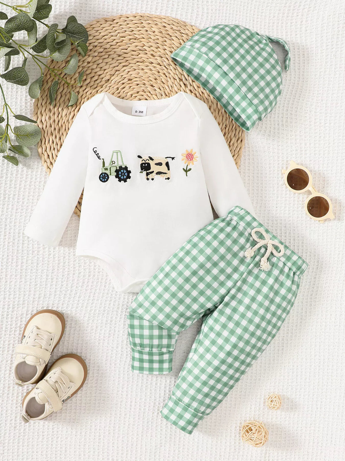 White farm-motif bodysuit with green gingham pants and a hat laid flat
