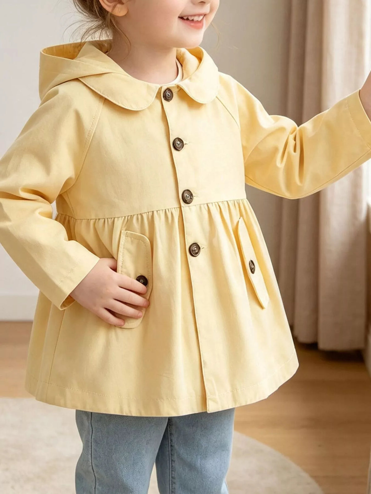 Pale yellow hooded button-front peplum coat on a child