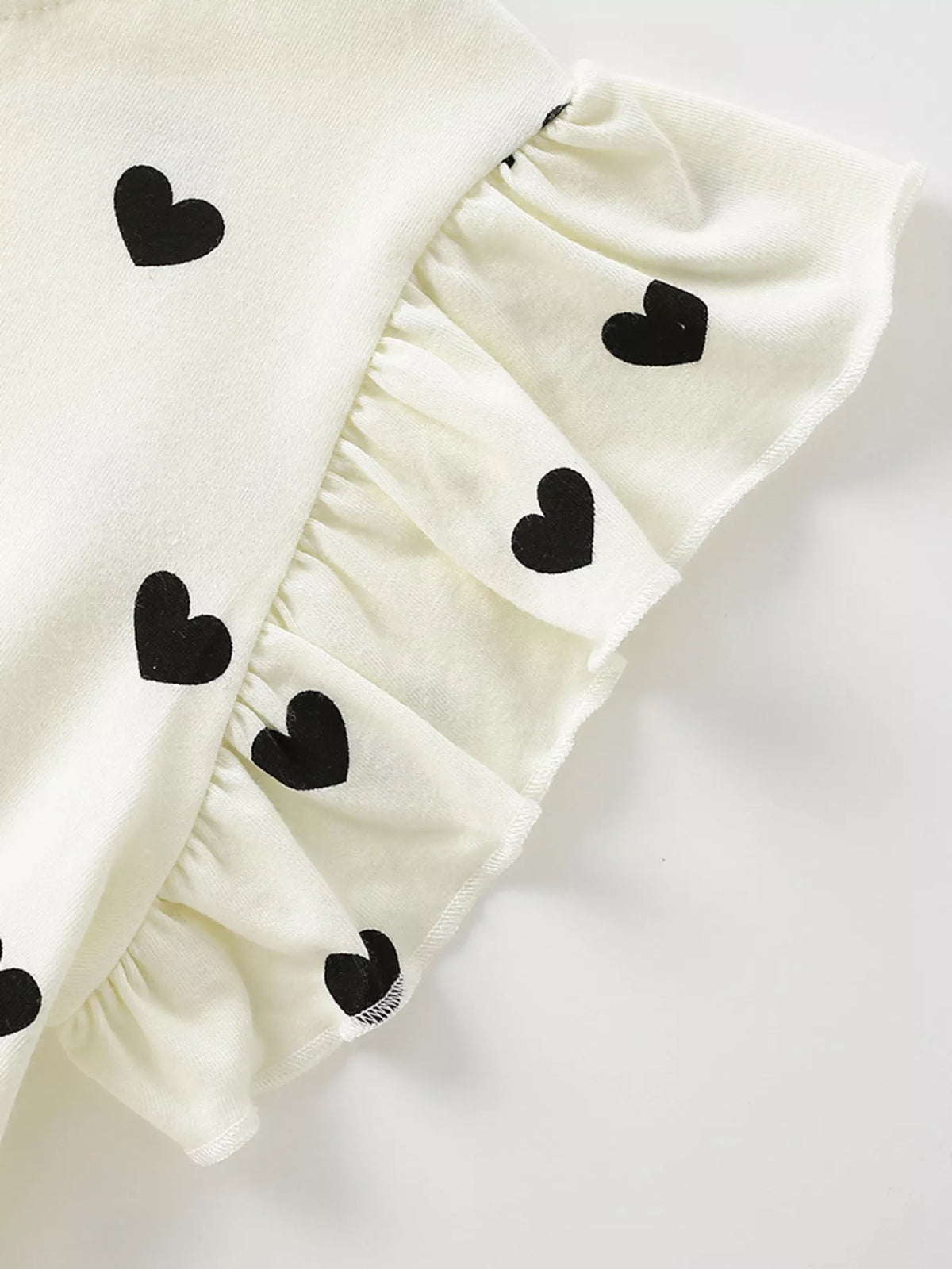 Ivory ruffled sleeve with black hearts
