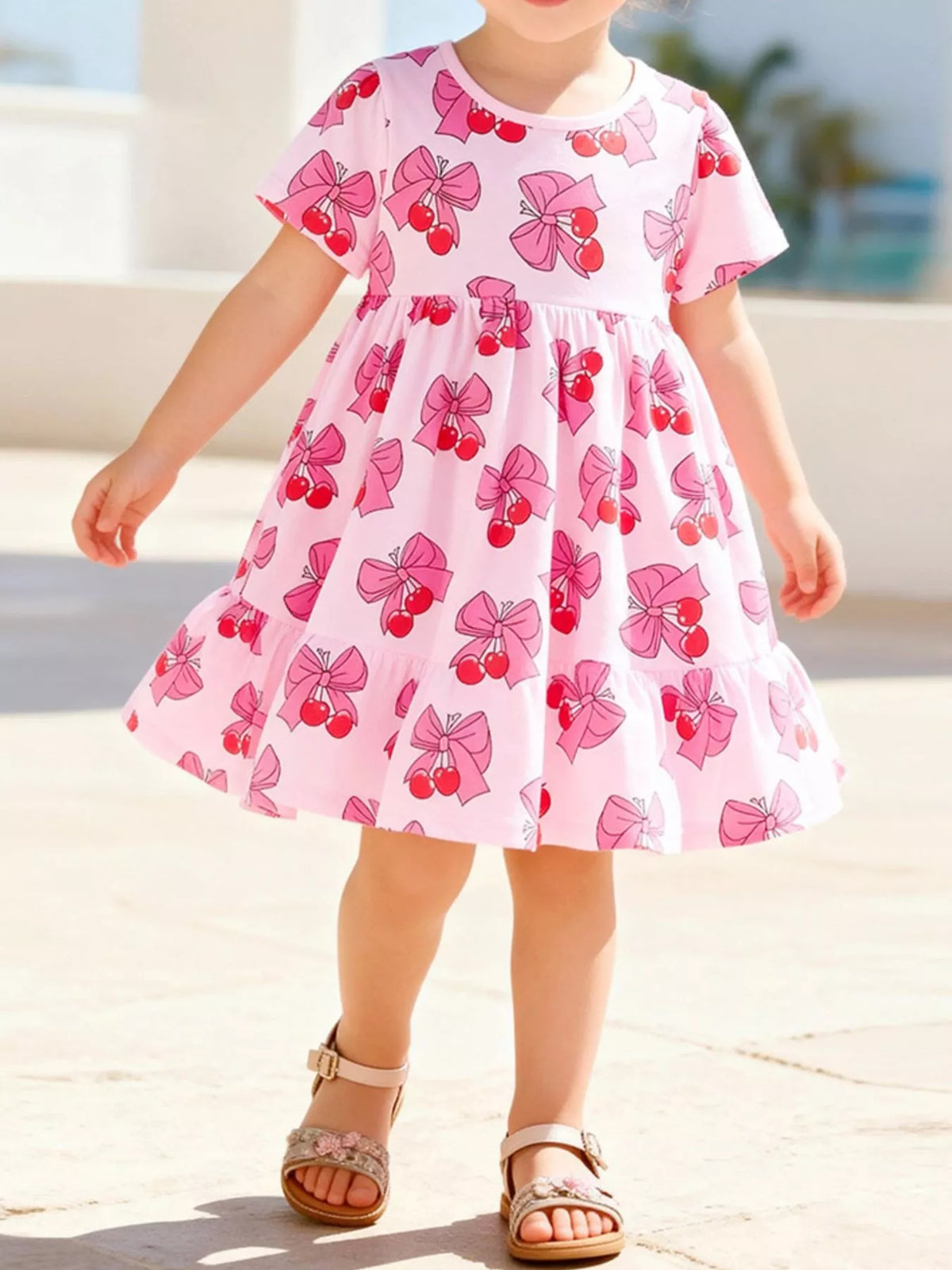 Pink cherry-and-bow print short-sleeve dress on a child