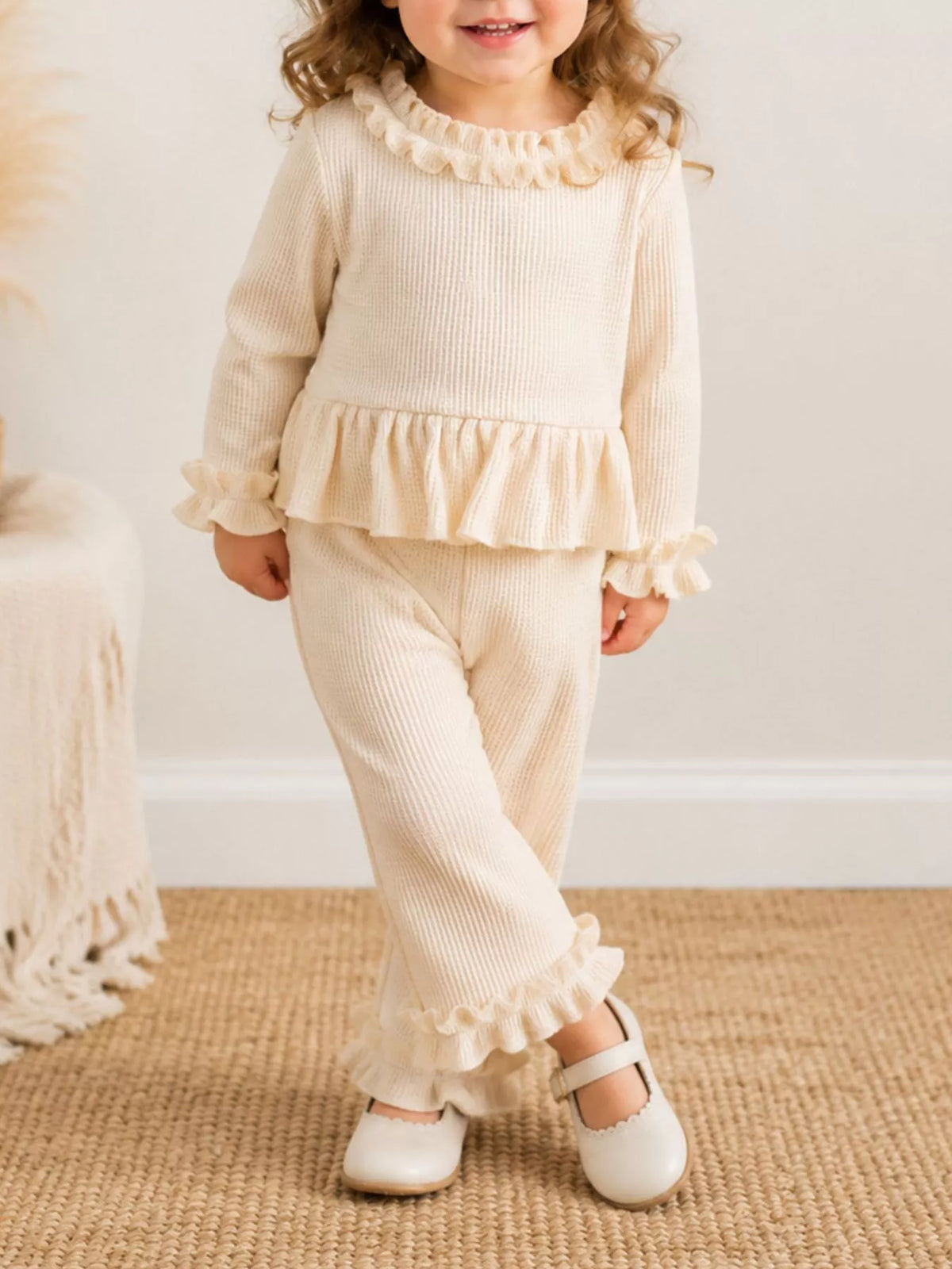 Cream outfit on a child with crossed ankles