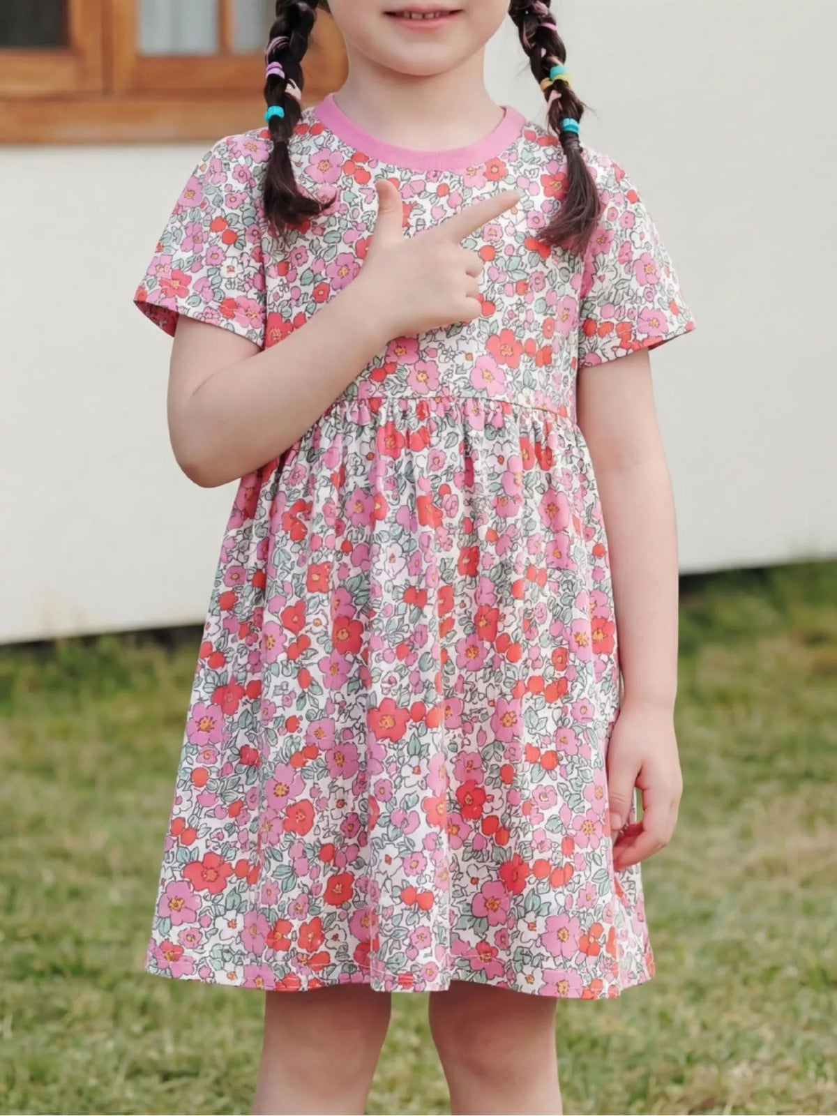 Pink floral short-sleeve dress with contrast neckline on a child