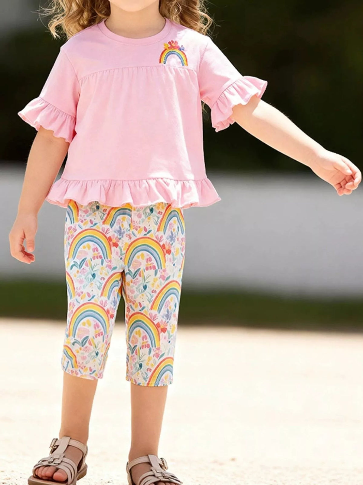Pink rainbow ruffle top with rainbow-print capri leggings on a child