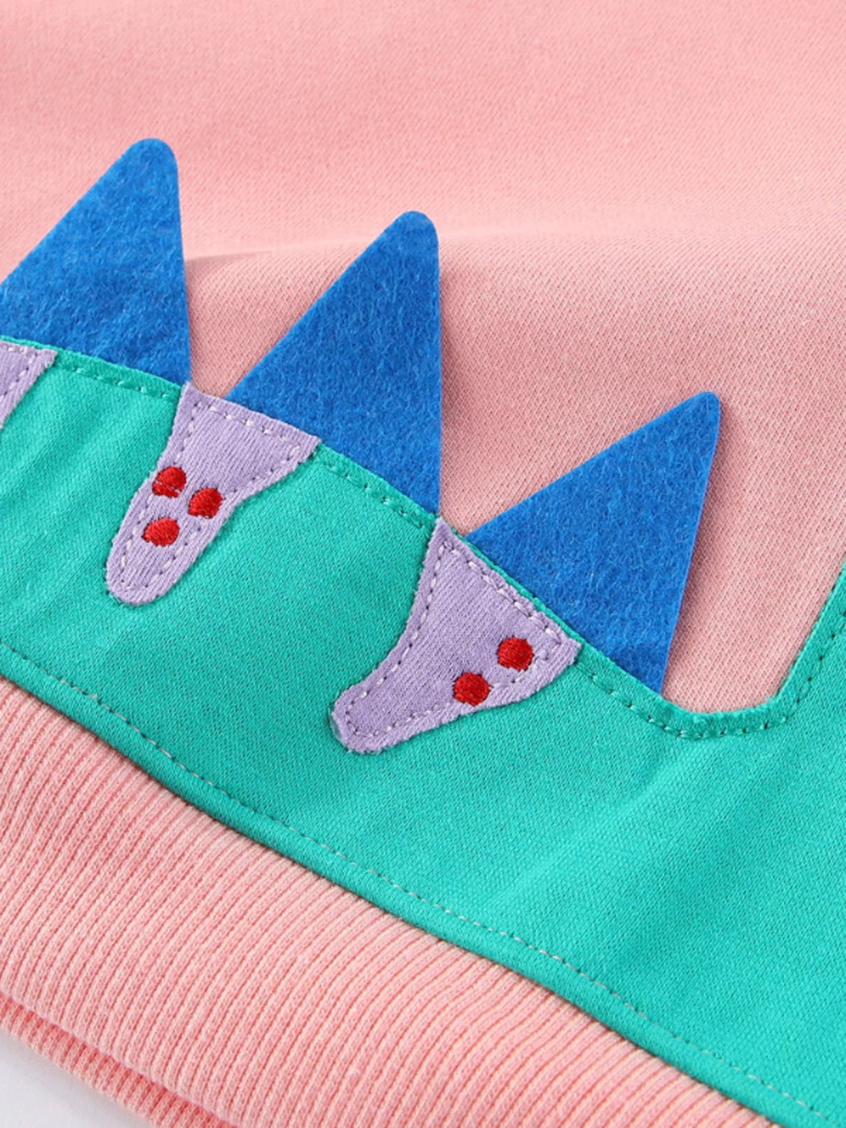 Pink dinosaur applique long sleeve top with blue spikes — dinosaur applique and blue spikes