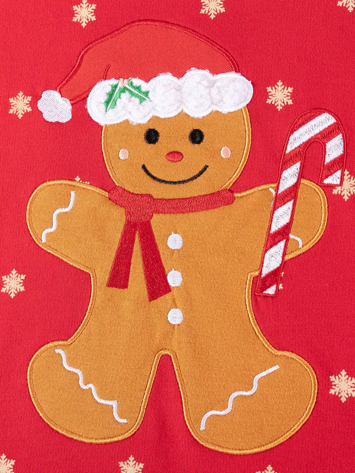 Gingerbread character wearing a Santa hat and holding a candy cane