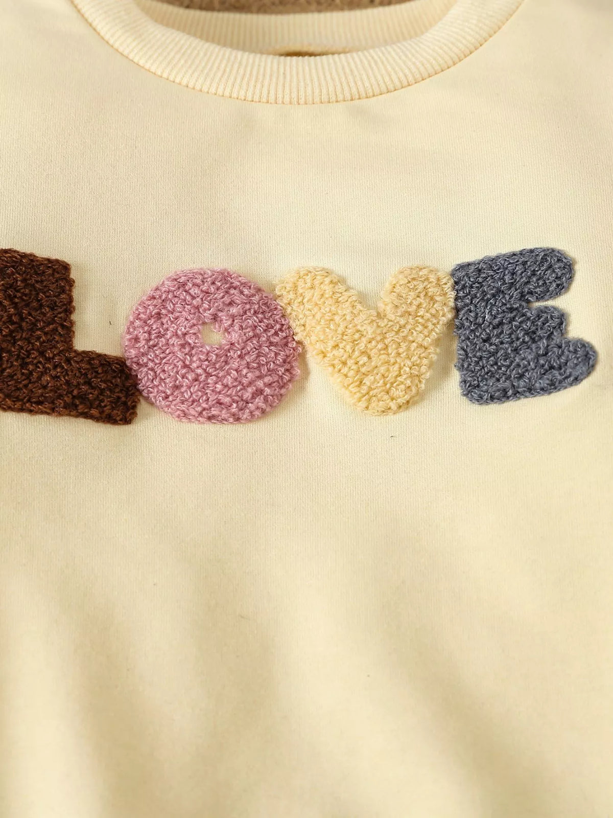 Textured Love applique on pale yellow fabric