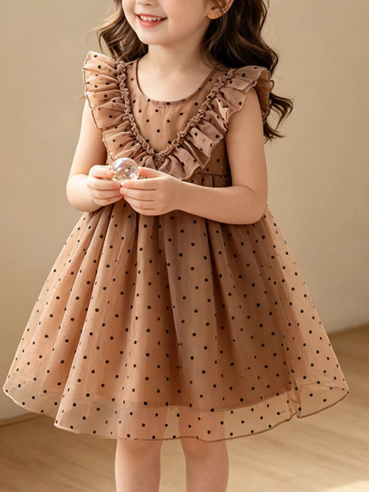 Caramel polka-dot dress with ruffled bodice trim on a child