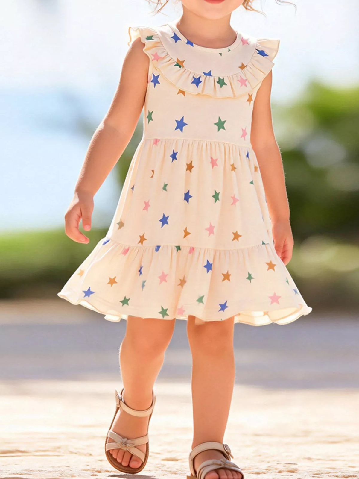 Cream star-print sleeveless dress with ruffle trim on a child