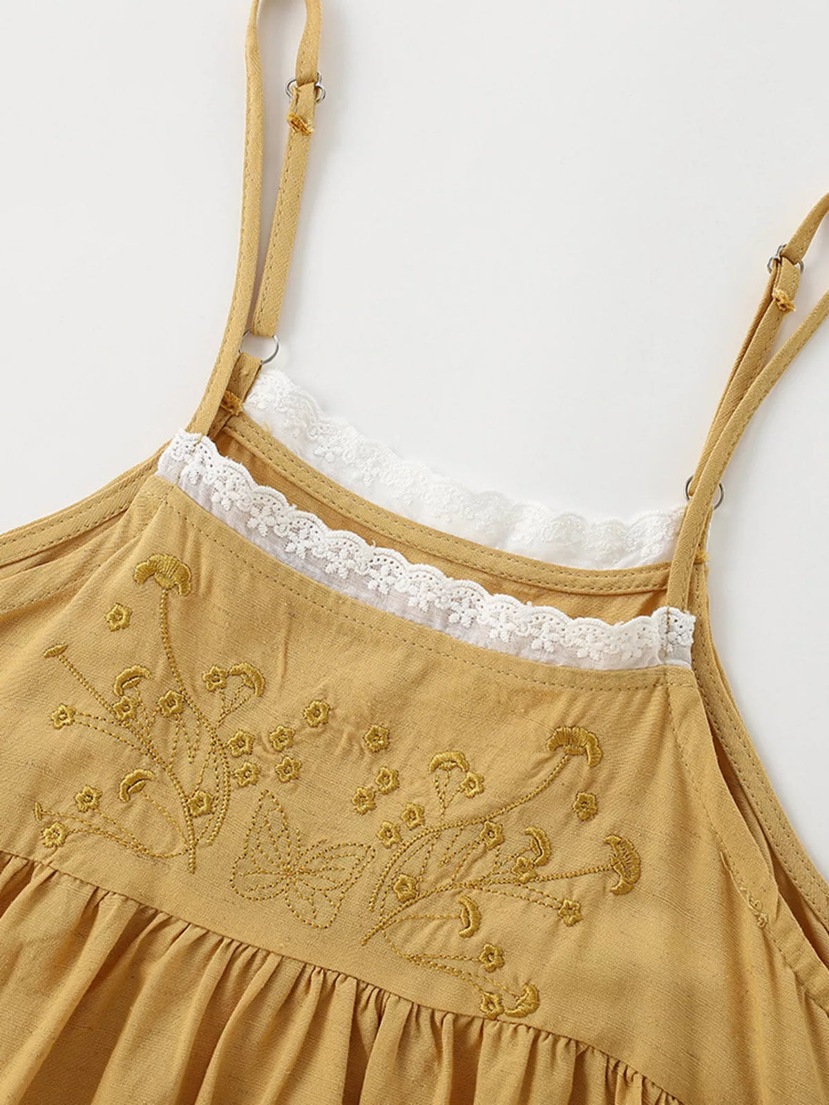 Thin shoulder straps and lace-edged embroidered bodice