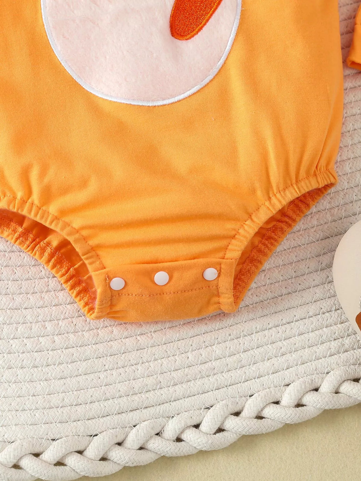 Snap closure on the orange bodysuit