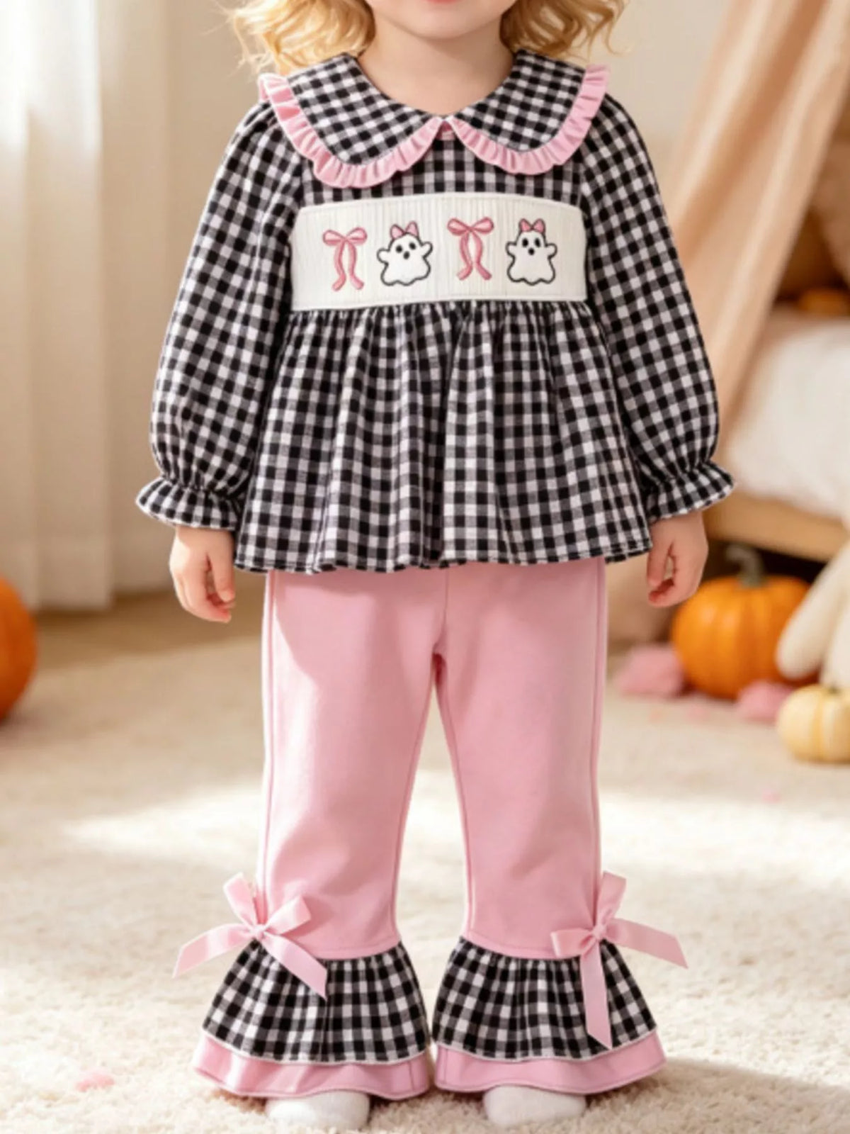 Black gingham ghost top with pink ruffle-hem pants on a child