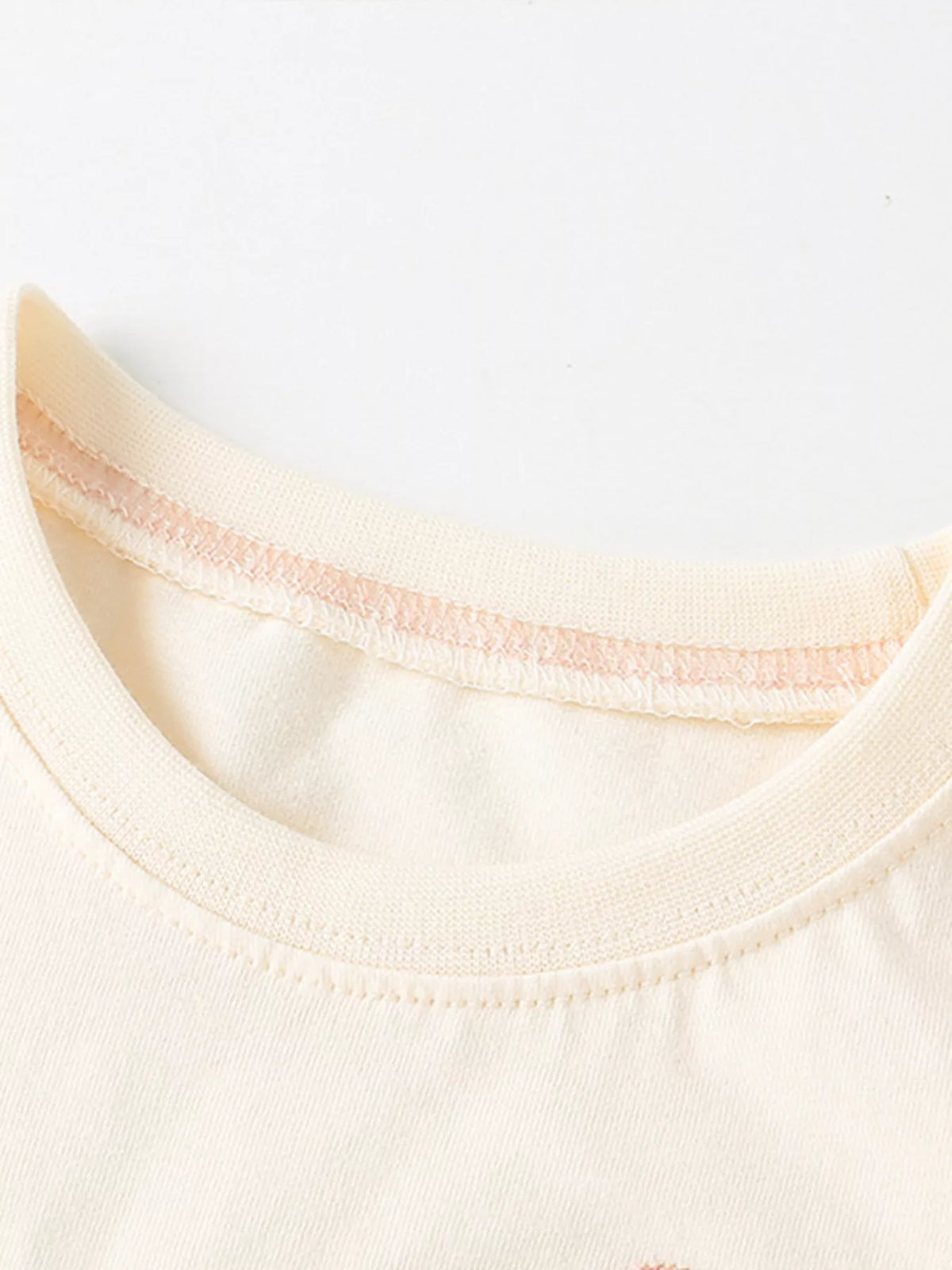 Cream abstract rainbow and leaf applique shirt — round neckline